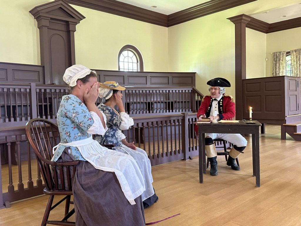 Reconstructed early colonial courtroom in Upper Canada with wooden benches and simple judge’s desk.