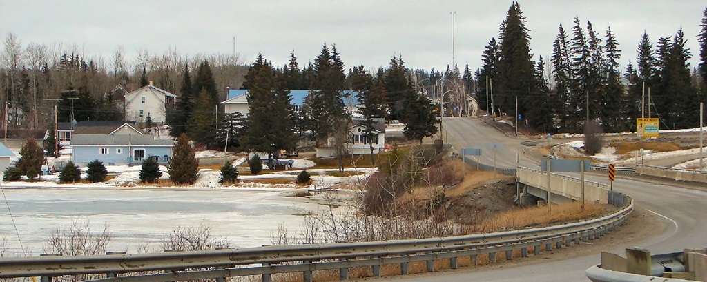Road winding around lake into village